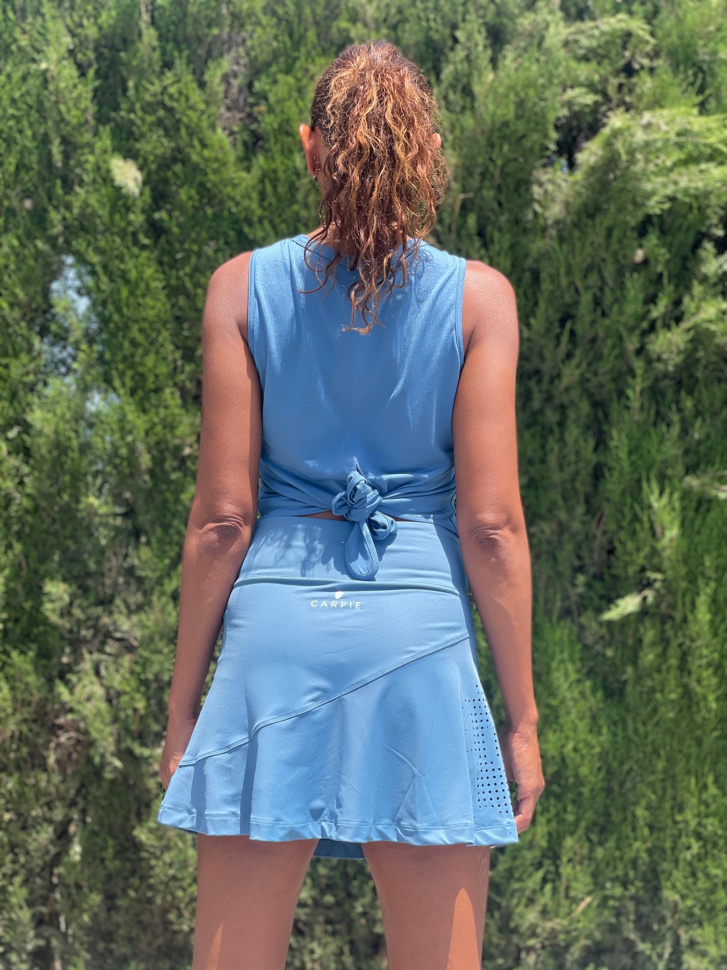 blue padel outfit with top and skirt. knot at the back on the padeltop